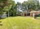 Large, well-kept backyard, featuring lawn, brick home and a shed at 6922 Woodstock Dr, Charlotte, NC 28210