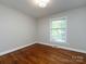 Bright and airy bedroom with hardwood floors, a large window, and a ceiling light at 6922 Woodstock Dr, Charlotte, NC 28210