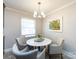 Bright dining area features a round white table, comfortable chairs, and modern lighting at 6922 Woodstock Dr, Charlotte, NC 28210