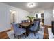Inviting dining room with a dark wood table, gray velvet chairs, and a view into the modern kitchen at 6922 Woodstock Dr, Charlotte, NC 28210