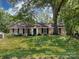A beautiful, brick home with an expansive lawn, mature trees, and a classic architectural style at 6922 Woodstock Dr, Charlotte, NC 28210