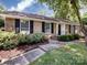 Attractive brick home featuring manicured landscaping, a walkway, and classic black shutters at 6922 Woodstock Dr, Charlotte, NC 28210