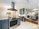 Open concept kitchen showcasing stainless steel range hood, granite counters, and view to the dining room at 6922 Woodstock Dr, Charlotte, NC 28210