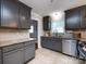 Modern kitchen with gray cabinets, stainless steel appliances, and a view into the adjacent rooms at 6922 Woodstock Dr, Charlotte, NC 28210