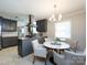 Bright kitchen featuring gray cabinets, stainless appliances, and an adjacent breakfast nook with seating at 6922 Woodstock Dr, Charlotte, NC 28210