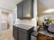 Modern kitchen with gray cabinetry, granite countertops, and view into the dining room and laundry area at 6922 Woodstock Dr, Charlotte, NC 28210