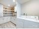 Well-organized laundry room with new washer, dryer, and built-in storage shelving at 6922 Woodstock Dr, Charlotte, NC 28210