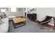 Stylish living room with a sectional, ottoman, curated decor, and hardwood floors under a patterned rug at 6922 Woodstock Dr, Charlotte, NC 28210