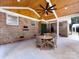 Covered brick patio with a wooden ceiling, ceiling fan, and outdoor dining set at 6922 Woodstock Dr, Charlotte, NC 28210
