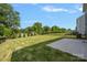 Spacious backyard featuring green grass, a concrete patio, and a sleek black fence at 699 Kitfox Nw Dr, Concord, NC 28027