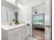 Well lit bathroom with a double sink vanity and large mirror, with bedroom view at 699 Kitfox Nw Dr, Concord, NC 28027