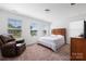 Bright bedroom with three windows, a striped bedspread, and a comfortable leather armchair at 699 Kitfox Nw Dr, Concord, NC 28027