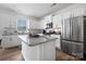 Bright kitchen featuring white cabinets, stainless steel appliances, granite countertops, and a center island with bar seating at 699 Kitfox Nw Dr, Concord, NC 28027