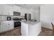 Modern kitchen featuring white cabinetry, granite countertops, stainless steel appliances, and a spacious center island at 699 Kitfox Nw Dr, Concord, NC 28027