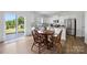 Eat-in kitchen featuring an adjacent dining area with hardwood floors, white cabinets, and stainless steel appliances at 699 Kitfox Nw Dr, Concord, NC 28027
