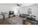 Bright living room with large gray sectional, ceiling fan, and plank flooring at 699 Kitfox Nw Dr, Concord, NC 28027