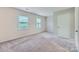 Spacious bedroom with two windows offering natural light, neutral paint, and carpet at 8221 Pineville Matthews Rd # G, Charlotte, NC 28226