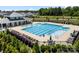 Beautiful community pool with a splash pad, surrounded by lounge chairs and lush landscaping at 9037 Remnick Dr, Gastonia, NC 28056