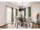 Bright dining area featuring a modern pendant light, a dark table, and access to the outdoor patio at 9037 Remnick Dr, Gastonia, NC 28056