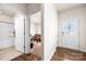 Bright foyer with hardwood floors, leading to a bathroom and living area with a tan couch and carpet at 9037 Remnick Dr, Gastonia, NC 28056
