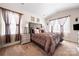 Well-lit main bedroom featuring a plush bed, carpeted floors, and tray ceilings at 9037 Remnick Dr, Gastonia, NC 28056