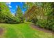 Well-manicured backyard with lush green grass and beautiful landscaping, surrounded by mature trees and shrubs at 9311 St Barts Ln, Huntersville, NC 28078