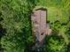 Aerial view of home surrounded by trees, mature lawn, and a driveway with a vehicle in the driveway at 104 Ridge Dr, Stanley, NC 28164