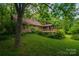 A home with a spacious wooden deck surrounded by lush greenery at 104 Ridge Dr, Stanley, NC 28164