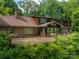Brick home with large deck, screened-in porch, and a backyard surrounded by mature trees, perfect for outdoor living at 104 Ridge Dr, Stanley, NC 28164