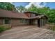 Brick home with large deck, screened-in porch, and a backyard surrounded by mature trees, perfect for outdoor living at 104 Ridge Dr, Stanley, NC 28164