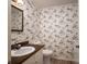 Small bathroom features decorative wallpaper, single sink vanity, toilet, and laminate flooring at 104 Ridge Dr, Stanley, NC 28164