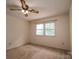 Simple bedroom with carpet, ceiling fan and large window at 104 Ridge Dr, Stanley, NC 28164