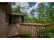 Spacious wooden deck with a screened-in porch offering a serene view of the lush, landscaped backyard at 104 Ridge Dr, Stanley, NC 28164