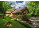 A brick home with wood accents, a covered parking area, and mature landscaping at 104 Ridge Dr, Stanley, NC 28164