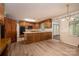 Open kitchen with wood cabinets, peninsula countertop, and adjacent breakfast nook with backyard views at 104 Ridge Dr, Stanley, NC 28164