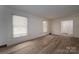 Bright, empty living room with wood floors and large windows for ample natural light at 104 Ridge Dr, Stanley, NC 28164