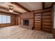 Cozy living room with wood-paneled walls, brick fireplace, built-in shelving, and ample natural light at 104 Ridge Dr, Stanley, NC 28164