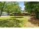 Manicured backyard featuring lush green grass, mature trees, and a charming brick home at 1102 E 13Th St, Kannapolis, NC 28083