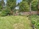 Lush backyard featuring a well-maintained lawn, mature trees, and a charming patio set for outdoor enjoyment at 1139 Yale Pl, Charlotte, NC 28209
