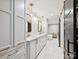 Bathroom with white cabinets, double sinks, marble counters, soaking tub, and gold accents at 1139 Yale Pl, Charlotte, NC 28209