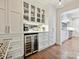 Butler's Pantry featuring wine fridge, glass cabinets, quartz counters and hardwood flooring at 1139 Yale Pl, Charlotte, NC 28209