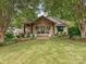 Inviting home exterior featuring a well-maintained lawn, stone accents, and mature trees at 1139 Yale Pl, Charlotte, NC 28209