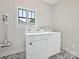 Bright laundry room features a window, tile floors, washer and dryer at 1139 Yale Pl, Charlotte, NC 28209