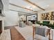 Spacious living room with hardwood floors, brick accent wall, and a view into the kitchen and dining area at 1139 Yale Pl, Charlotte, NC 28209