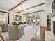 Open-concept living room with beamed ceilings, hardwood floors, and large sliding doors to the outside at 1139 Yale Pl, Charlotte, NC 28209