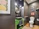 Unique powder room featuring stylish sink, mirror and fixtures with dark paneled walls at 1139 Yale Pl, Charlotte, NC 28209