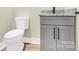 Close-up of a sleek half bathroom featuring gray cabinetry, granite countertop, black hardware, and a modern toilet at 124 Starboard Ln, Statesville, NC 28677