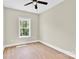 Light-filled bedroom features neutral walls, wood-look floors and modern ceiling fan, complemented by a window with treetop views at 124 Starboard Ln, Statesville, NC 28677