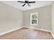 This bedroom features a modern ceiling fan, a window with natural light and sleek, wood-look floors at 124 Starboard Ln, Statesville, NC 28677