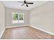 This bedroom boasts wood-look floors, a modern ceiling fan and large window with natural light and neutral walls at 124 Starboard Ln, Statesville, NC 28677